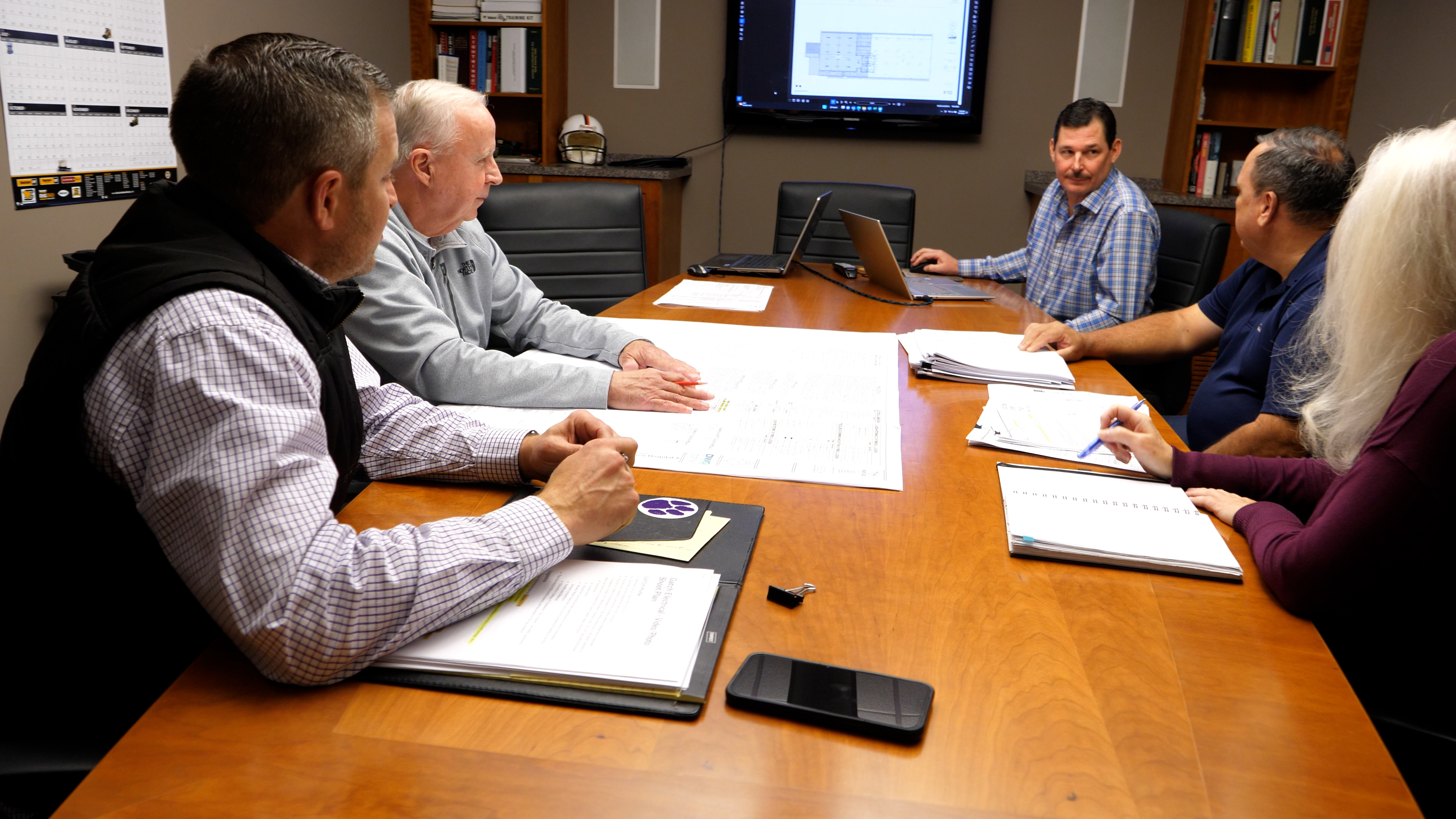 office staff sitting around table talking in conference room
